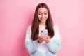Photo of cheerful positive young woman hold look phone like reaction isolated on pastel pink color background