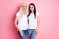 Photo of cheerful pretty aged mother young daughter ladies generation hugging spend time together wear white t-shirts Royalty Free Stock Photo