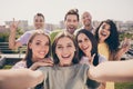 Photo of cheerful pretty girls guys doing selfie show v-sign have fun party on roof terrace outside