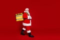 Photo of cheerful pretty man pensioner dressed santa claus costume carrying delivery rucksack empty space isolated red