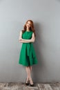 Cheerful redhead young lady in green dress