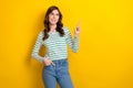 Photo of cheerful satisfied pretty woman striped shirt with jeans direct finger look empty space ad empty space isolated