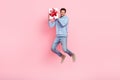 Photo of cheerful stylish man wear trendy blue clothes rejoice get xmas gift empty space isolated on pink color