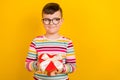 Photo of cheerful tricky boy wear stylish clothes hold giftbox heart shape look interested empty space isolated on Royalty Free Stock Photo