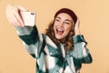 Photo of cheerful woman taking selfie on cellphone and laughing