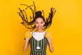 Photo of cheerful young afro american woman hold oranges fly hair wind isolated on yellow color background