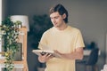 Photo of cheerful young creative guy read book education time think wear yellow t-shirt home indoors Royalty Free Stock Photo