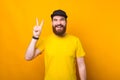 Photo of a cheerful young man is showing the peace sign smiling at the camera Royalty Free Stock Photo