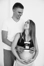 Photo of cheerful young man standing with his pregnant woman isolated over white background wall. Young couple expecting a baby Royalty Free Stock Photo