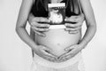 Photo of cheerful young man standing with his pregnant woman isolated over white background wall. Young couple expecting a baby Royalty Free Stock Photo