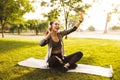 Photo of cheerful young woman 20s in sportswear listening to mus Royalty Free Stock Photo