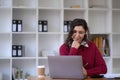 Photo of cheerful young woman working using computer laptop concentrated and smiling at office Royalty Free Stock Photo