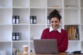 Photo of cheerful young woman working using computer laptop concentrated and smiling at office Royalty Free Stock Photo