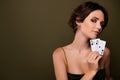 Photo of chic classy girl hold playing cards cheating in poker look on green empty space background Royalty Free Stock Photo