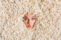 Photo of childish impressed young woman face smiling white teeth curious peeking hole covered tasty caramel popcorn