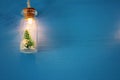 photo of Christmas tree in the masson jar garland light over wooden blue background. Royalty Free Stock Photo