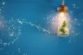 photo of Christmas tree in the masson jar garland light over wooden blue background.