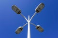 Photo of 4 city street light lamps on a background of blue clear sky