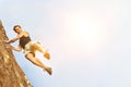 Portrait of Climber Jumping off Cliff with yellow lens flare Royalty Free Stock Photo