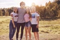 Photo of close friends stand outdoor, have picnic together, embrace and smile happily at camera, have good relationship, dressed i Royalty Free Stock Photo