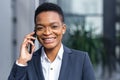 Photo of close up portrait of young handsome business woman, african american woman talking on the phone, smiling and rejoicing Royalty Free Stock Photo