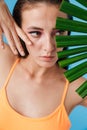 Photo closeup of alluring beautiful woman posing with palm leaf