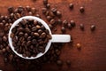 Photo closeup of coffee beans in white cup. Rusty background.