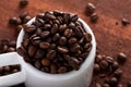 Photo closeup of coffee beans in white cup. Rusty background. Royalty Free Stock Photo