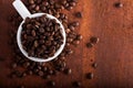 Photo closeup of coffee beans in white cup. Rusty background. Royalty Free Stock Photo