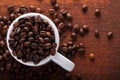 Photo closeup of coffee beans in white cup. Rusty background. Royalty Free Stock Photo