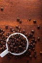 Photo closeup of coffee beans in white cup. Rusty background. Royalty Free Stock Photo