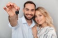 Photo closeup of european couple in casual clothing hugging while unshaven man holding key Royalty Free Stock Photo