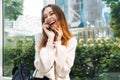 Photo closeup of happy charming woman laughing and talking on cellphone while sitting near window in building indoors Royalty Free Stock Photo