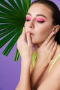 Photo closeup of seductive brunette woman posing with palm leaf