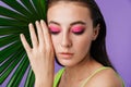 Photo closeup of seductive young woman posing with palm leaf