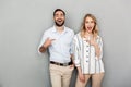 Photo closeup of smiling couple in casual clothing pointing fingers to each other Royalty Free Stock Photo
