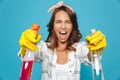 Photo closeup of displeased upset woman 20s in yellow rubber gloves for hands protection screaming while holding two detergent sp