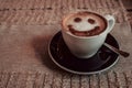 Photo of coffee cup of cappuccino on a saucer with print a smile on foam