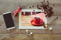 Photo of coffee cup on wooden table with smart phone and coffee beans. View from above