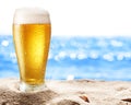 Photo of cold beer botle in the sand.