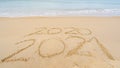 Photo of coming New Year 2021 Text and leaving year of 2020 of lettering Text on the beach with wave and white sea foam Numbers Royalty Free Stock Photo