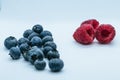 Composition of a pile of blueberries and raspberries with white background