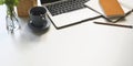 Photo of computer laptop, coffee cup, notebook, diary, pencil, pencil holder, plant in vase putting on white working desk. Royalty Free Stock Photo