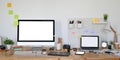 Photo of computer laptop and computer monitor with white blank screen putting on wooden working desk. Royalty Free Stock Photo