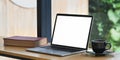 Photo of computer laptop with white blank screen, book and coffee cup putting on wooden counter bar . Royalty Free Stock Photo