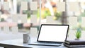 Photo of Computer laptop with white blank screen, potted plant, coffee cup and stack of books. Royalty Free Stock Photo