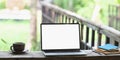 Photo of Computer laptop with white blank screen putting on wooden long table. Royalty Free Stock Photo