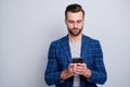 Photo of concentrated man with bristle looking into screen of telephone while having conversation with business partner Royalty Free Stock Photo