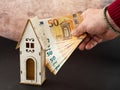 photo concept of a hand that puts money into the purchase or maintenance of the house