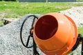 Photo concrete mixer installed on the construction site next to a pile of sand and gravel.